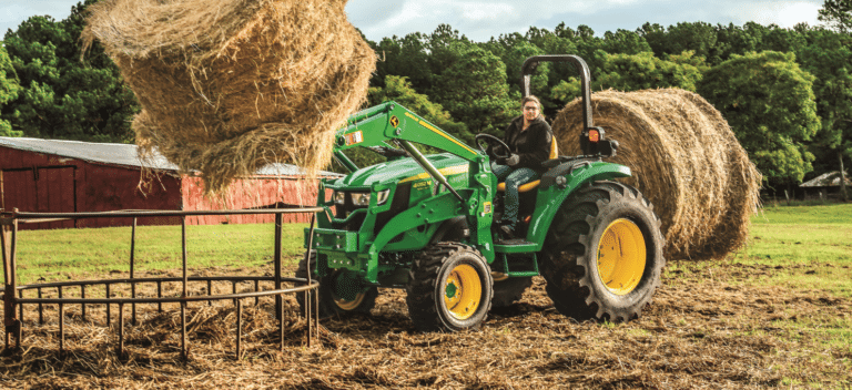 Woman moving hay bales with a utility tractor available at Minnesota Equipment