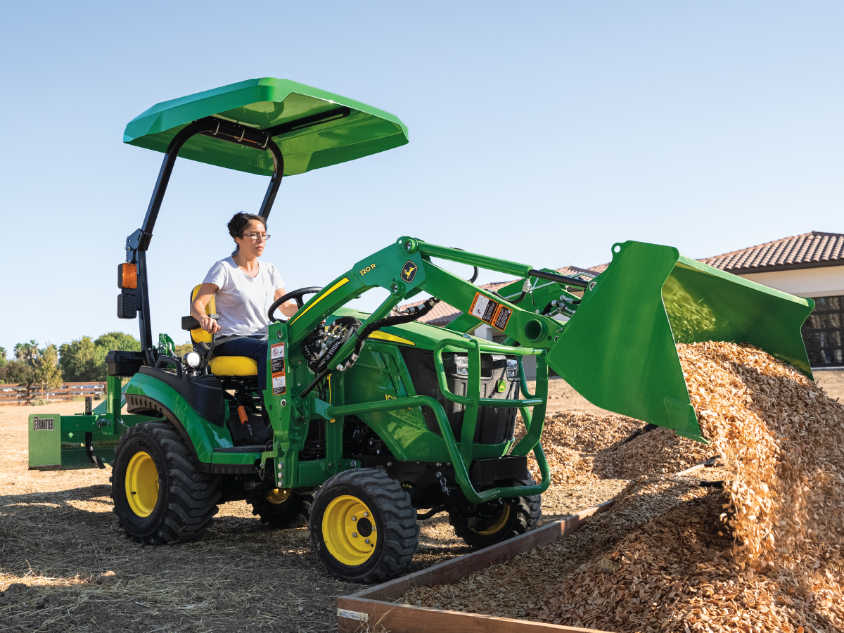 Person driving a John Deere 1025R Compact Tractor
