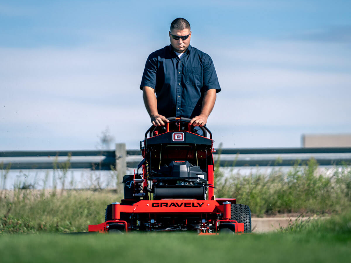 man riding a gravely stand-on mower
